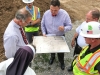 Aquinas College staff and construction crewmembers consult an 1876 map of the property