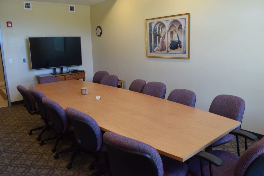 First Floor Board Room with large conference table and flatscreen TV for small gatherings and meetings.