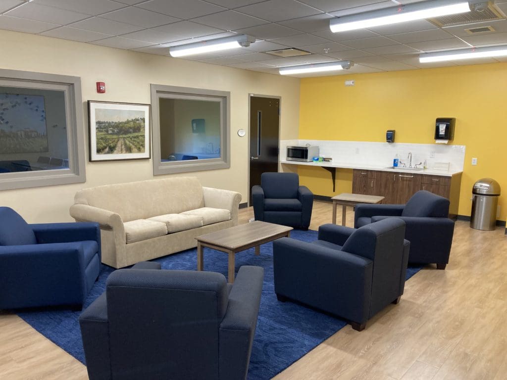 Second Floor Lounge has a couch and comfy chairs with a nearby sink, refrigerator, and microwave for small meetings and gatherings.